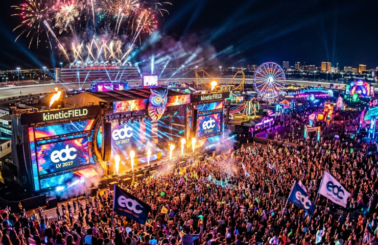 Large crowd at EDC Las Vegas 2027 festival stage with fireworks and colorful lights at night
